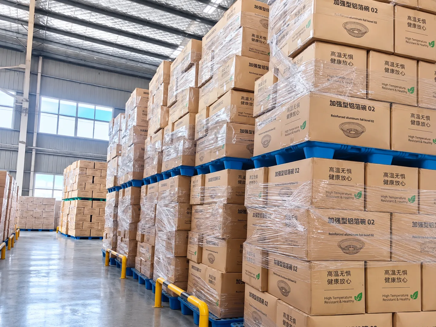 Finished cartons stacked on pallets inside a factory warehouse.